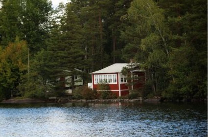 picture of a red cabin on a peaceful lake