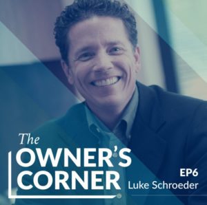 A person with short, curly hair is smiling while wearing a dark blazer. Text on the image reads "The Owner's Corner EP6 Luke Schroeder." The background has a blue overlay with diagonal stripes, highlighting Luke Schroeder.