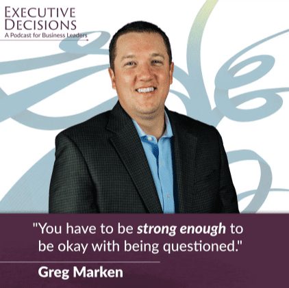 A man wearing a dark blazer and light blue shirt is smiling in front of a background with abstract swirl designs. The text on the image reads, “Executive Decisions: A Podcast for Business Leaders. 'Executive leadership means being strong enough to be okay with being questioned.' - Greg Marken.”