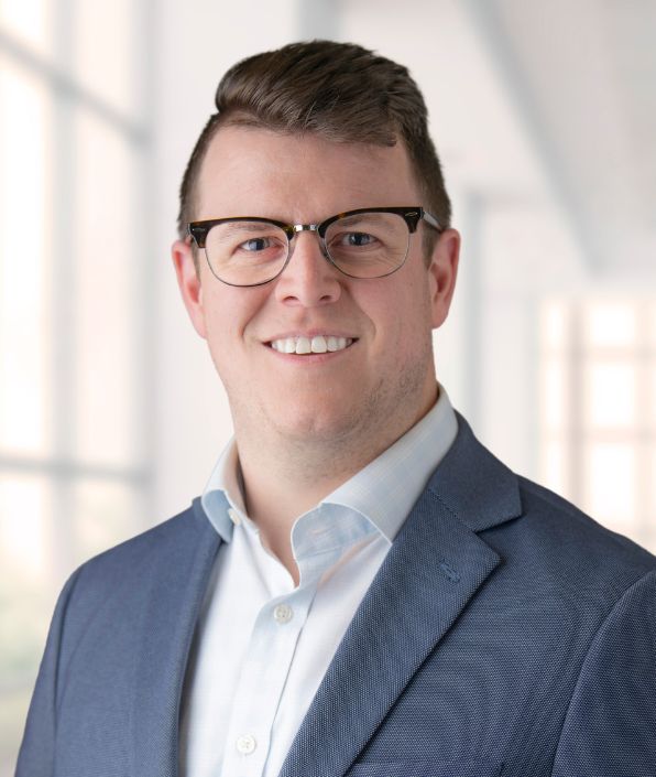 man with glasses and brown hair on suit coat