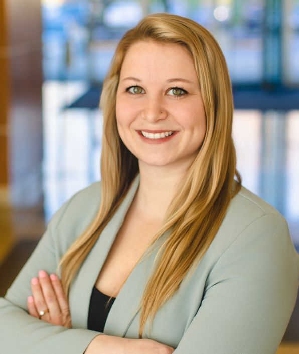 A woman with long blonde hair and a light green jacket