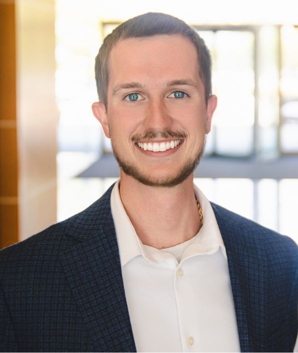 young man with blue eyes, moustache and beard smiling
