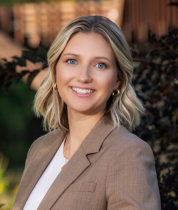 woman with blond hair and blue eyes in a tan blazer with white undershirt