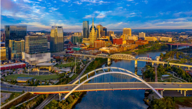 a daytime picture of the Nashville city scape shows a bridge over a river