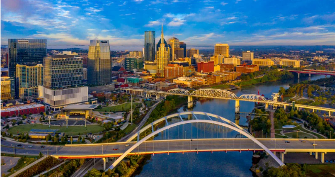 Aerial view of the Nashville skyline, river, and bridges at sunset, representing the location served by SYM Financial Advisors, an independent, commission-free fiduciary with 55+ years of serving clients.