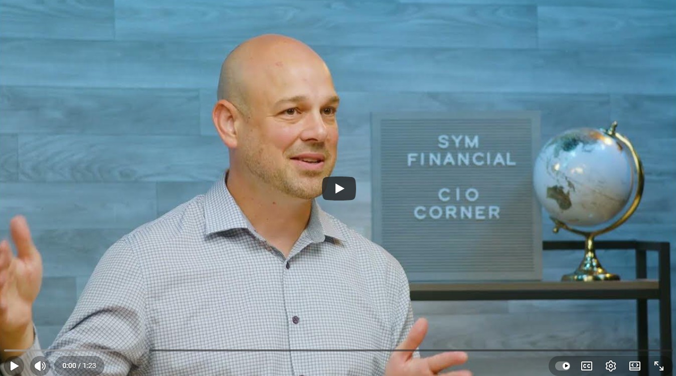 CIO Andy Popenfoose is in a white plaid button down talking with his hands with a sign behind him that reads "SYM FINCIAL CIO CORNER"