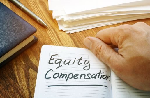 A notebook page opens up to read Equity Compensation, with a hand holding the book open