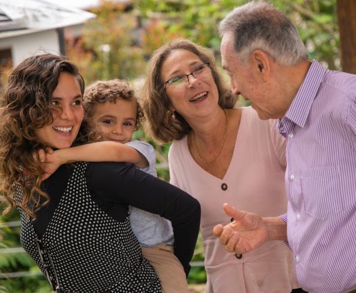 A multigenerational family smiling together outside